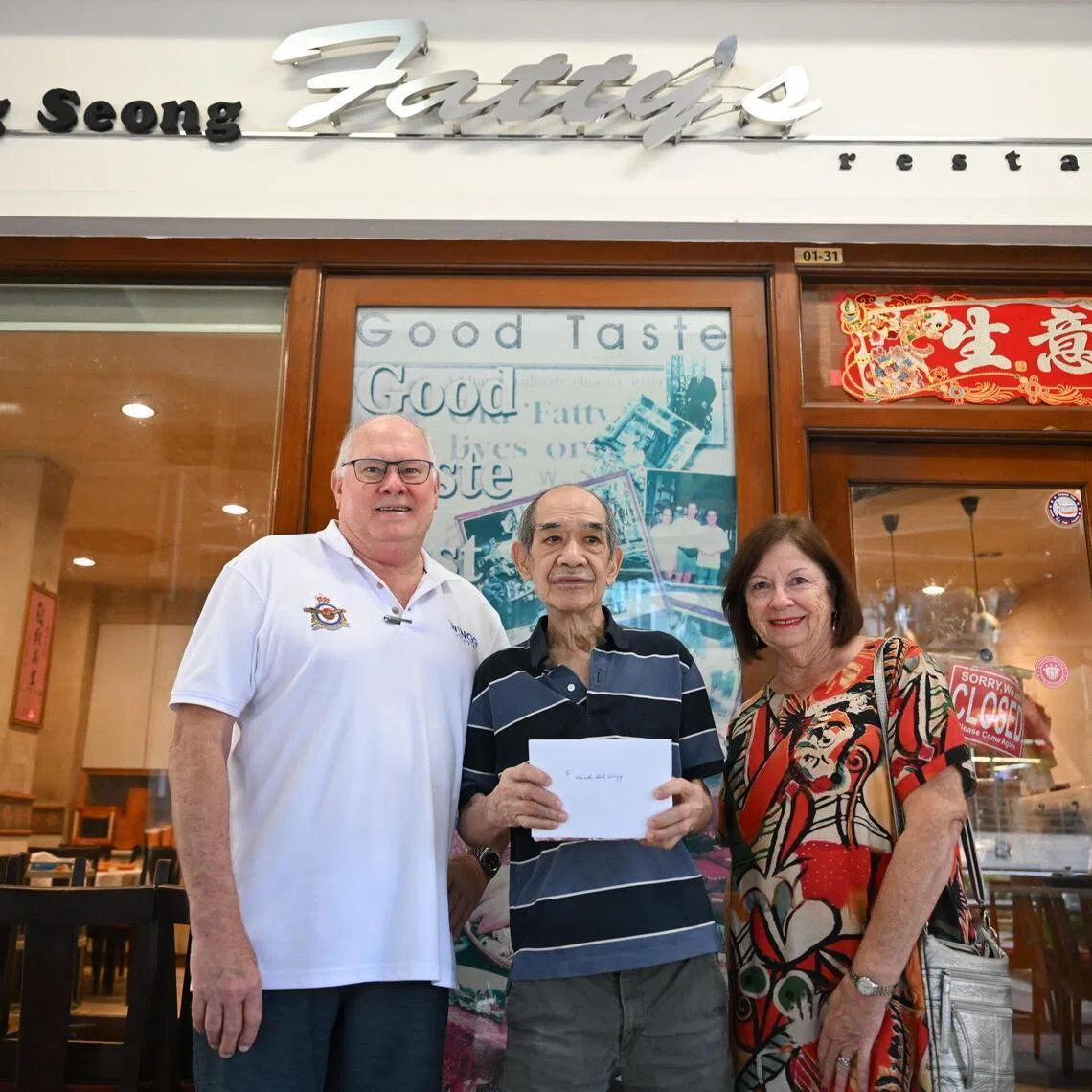 Ronald Haack (left) and his wife Elizabeth Haack presenting Au Kok Wing, one of the owners of the Wing Seong Fatty’s restaurant with a gift to show appreciation for the restaurant.