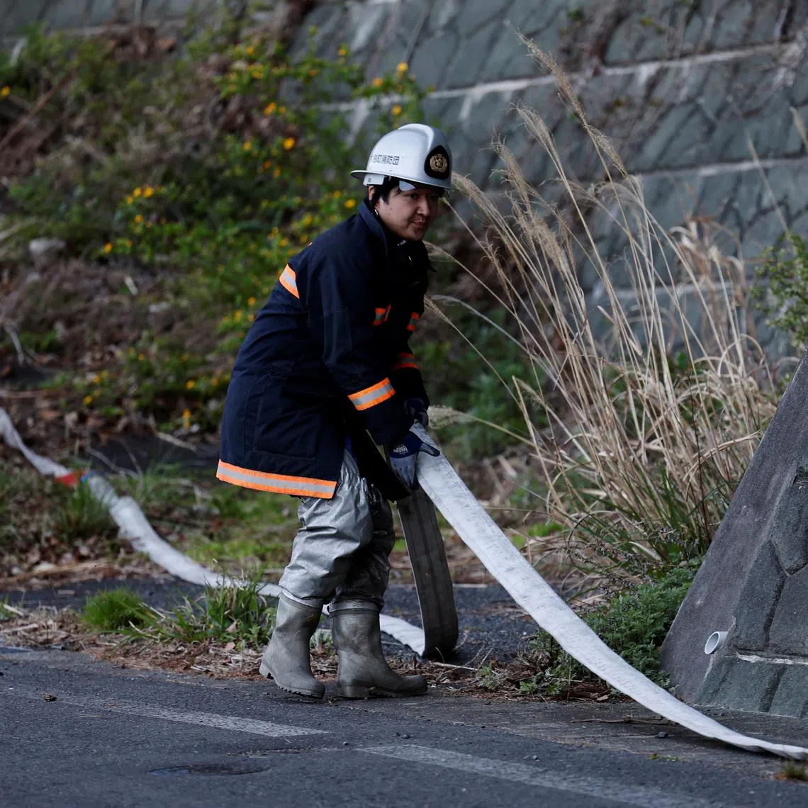 Volunteer firefighter Ryota Haga prepares to connect fire hoses to battle a wildfire in Otsuchi, Iwate Prefecture, Japan, April 26, 2026. REUTERS/Kim Kyung-Hoon