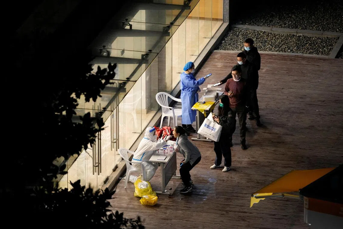 A woman gets tested at a nucleic acid testing site, following the coronavirus disease (COVID-19) outbreak in Shanghai, China, November 24, 2022. REUTERS/Aly Song
