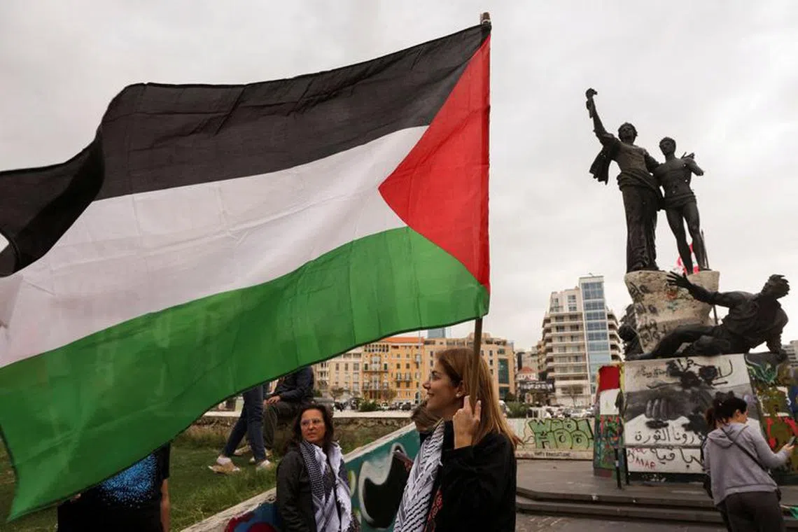 A demonstrator holds a Palestinian flag during a sit-in, in response to the global call for strike in solidarity with Gaza and Palestinian people, at Martyrs' Square, downtown Beirut, Lebanon, December 11, 2023. REUTERS/Mohamed Azakir