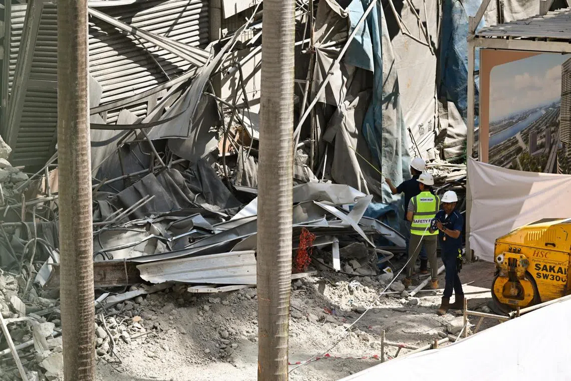 MOM officers (in blue) investigating the accident where a worker was killed when a wall collapsed during demolition works at the Fuji Xerox Towers site.