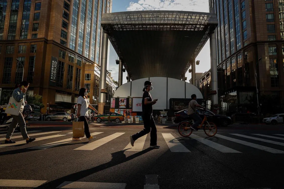 People cross a street in the central business district of Beijing, China, June 14, 2022. China is encouraging college graduates to work in the rural areas as the urban unemployment for the youth remains high. The unemployment rate for people aged 16 to 24 rose to 18.4 percent in May, up from 18.2 percent, while the unemployment rate in 31 large cities and towns increased to 6.9 percent up from 6.7 percent and the unemployment rate of the population aged 25-59 went down to 5.1 percent from 5.3 percent.