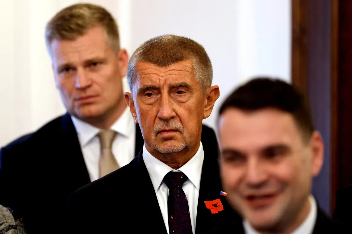 Leader of ANO party Andrej Babis stands between the leader of the Motorists party Petr Macinka and the honorary president of the Motorists party Filip Turek after signing a coalition agreement at the Czech Parliament in Prague, Czech Republic, November 3, 2025. REUTERS/David W Cerny