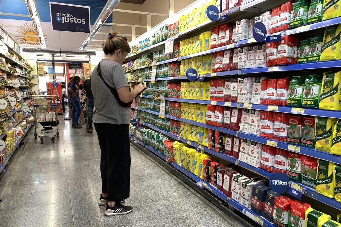 Ms Monica Schenone checking the prices at a supermarket in Buenos Aires.
