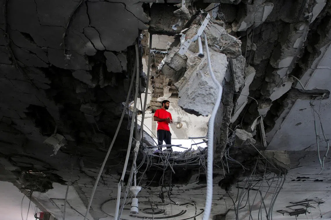 A person stands inside a building, damaged in an Israeli strike, amid the ongoing conflict between Israel and the Palestinian Islamist group Hamas, in Rafah, in the southern Gaza Strip, May 3, 2024. REUTERS/Hatem Khaled