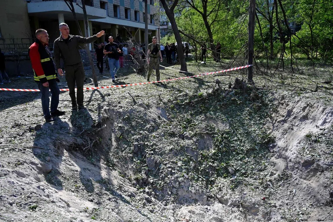 Mayor of the Ukrainian capital Kyiv, Vitali Klitschko (2R) speaks with a rescue worker as he examines a crater near a polyclinic damaged as a result of a downed missile explosion during a Russian attack on Kyiv on June 1, 2023. 