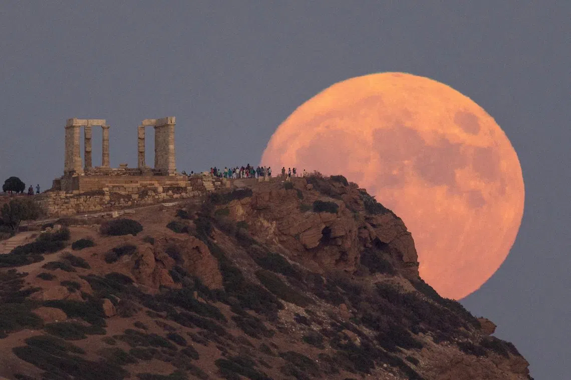 A full moon known as the "Blue Moon" rising behind the Temple of Poseidon, in Cape Sounion, near Athens, Greece, Aug 30, 2023. 
