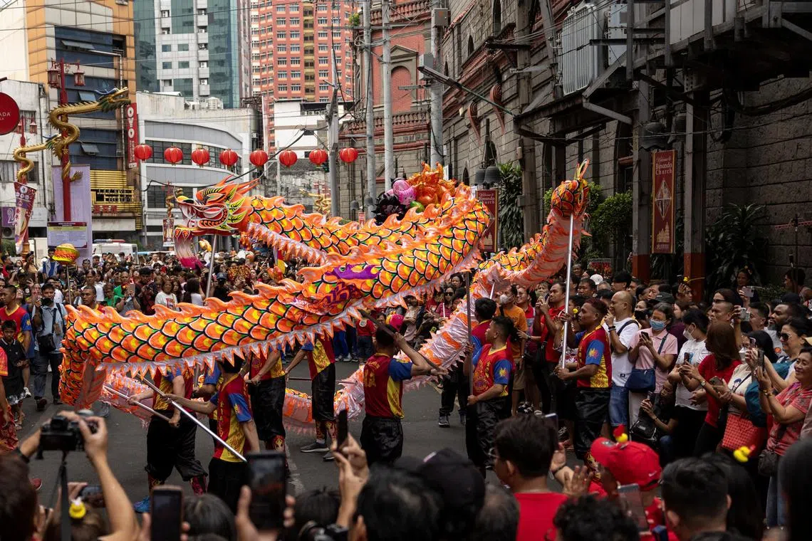 People watching a dragon dance, during the Lunar New Year celebrations at Binondo, the Chinatown of Manila, Philippines, Feb 10, 2024. 