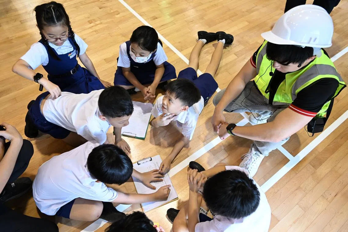 Students learning about water conservation  at the DBS Sustainability Sparks initiative booth at Mee Toh School on June 30, 2023.