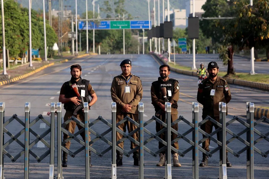 Police officers stand guard behind a barricade near Serena Hotel, as Pakistan prepares to host the U.S. and Iran for the second round of peace talks, in Islamabad, Pakistan, April 25, 2026.