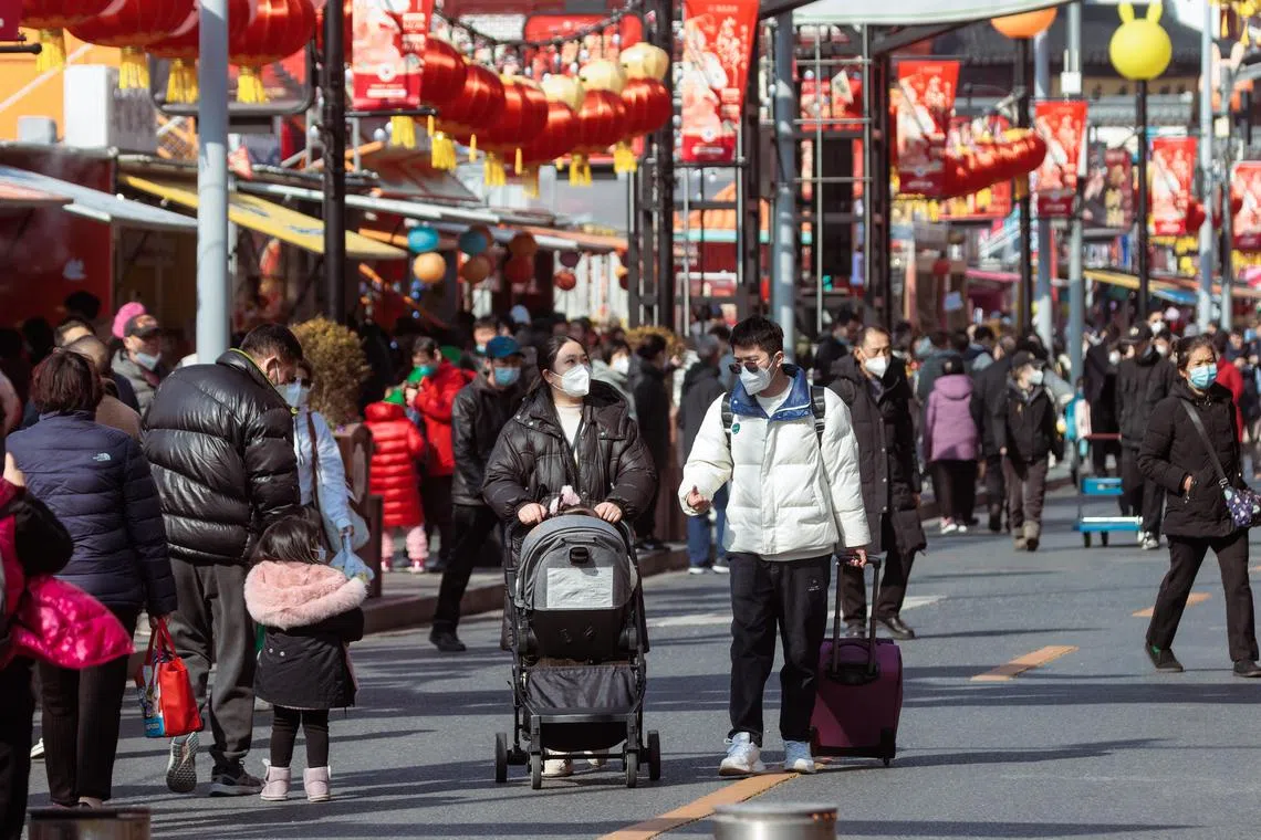 People walking along a shopping street in Shanghai, ahead of Chinese New Year celebrations, on Jan 19, 2023.