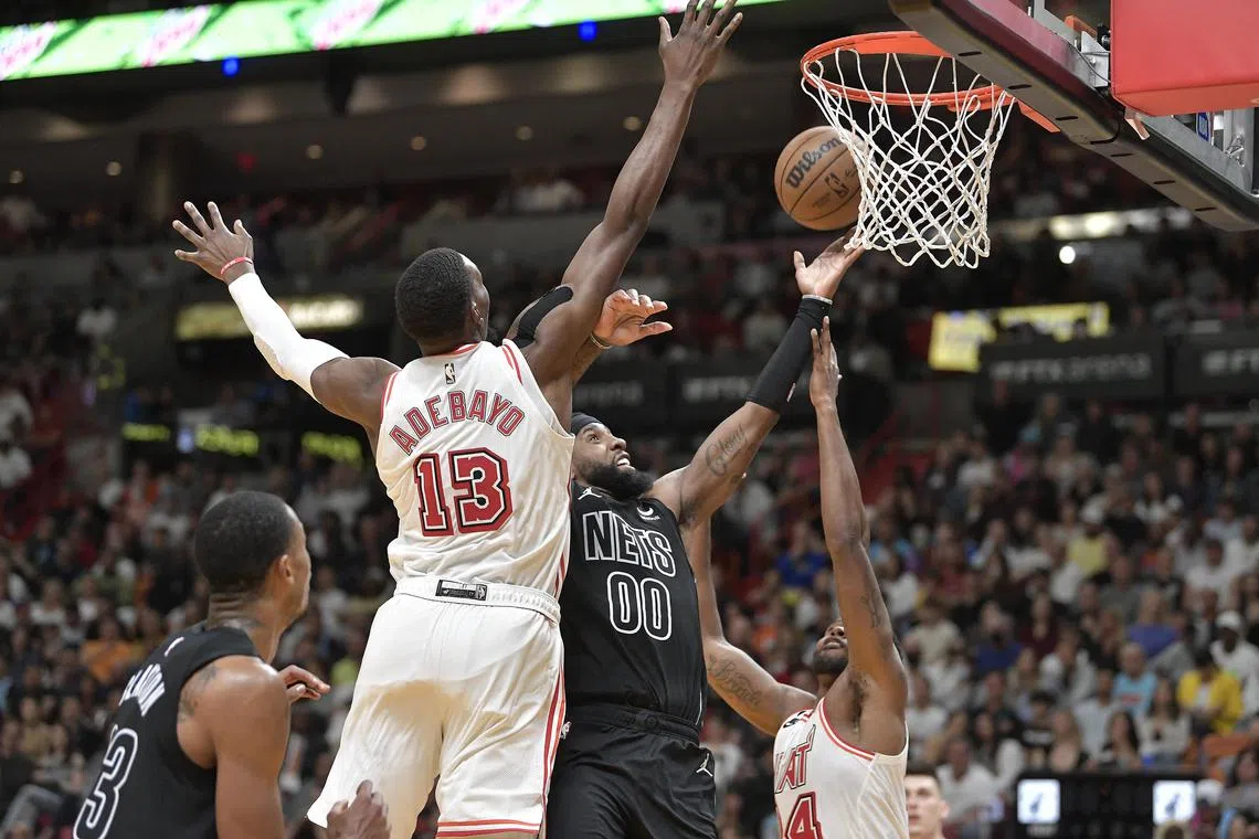Brooklyn Nets forward Royce O'Neale trying to score over Miami Heat centre Bam Adebayo and forward Haywood Highsmith during the fourth quarter at FTX Arena in Miami on Sunday. O’Neale hit the game-winning put-back with 3.2 seconds left.