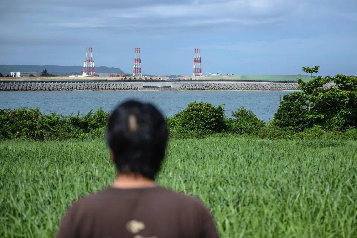 Mr Takemasa Kinjo looking on at the construction site of the new Henoko military base for US forces near his residence in Nago city, Okinawa Prefecture.