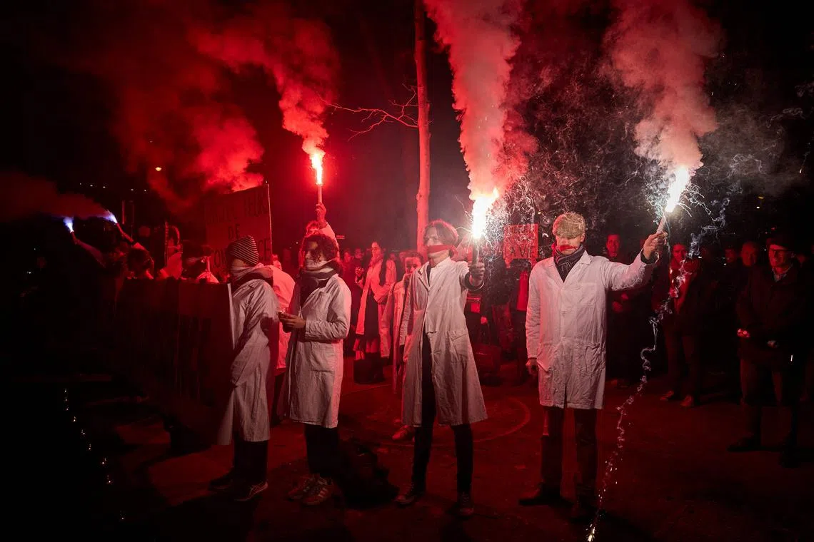 Protestors with cloths covering their mouths, light flares during a silent pro-life demonstration in Paris, on Feb 28 as the Senate started debates for inclusion of abortion in the constitution. 