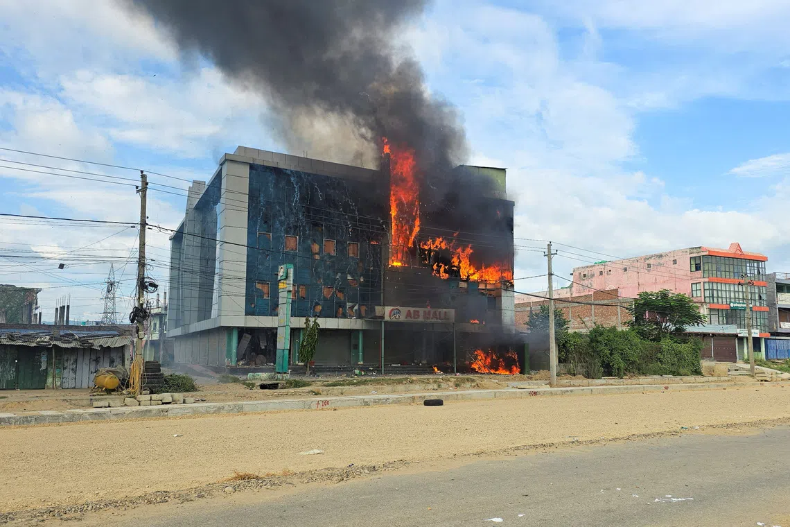Smoke and fire rise from a mall after it was vandalised following a clash between two communities in Siraha, Nepal on July 30.