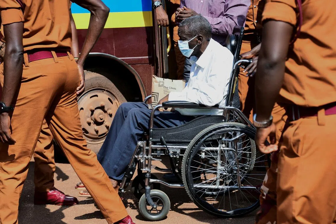 Prison warders wheel Uganda's four-time presidential candidate Kizza Besigye to the court room where he was charged alongside his colleague Obeid Lutale and Captain Denis Oola, with treason at the Chief Magistrate Court in Nakawa suburb of Kampala, Uganda, February 21, 2025. REUTERS/Abubaker Lubowa