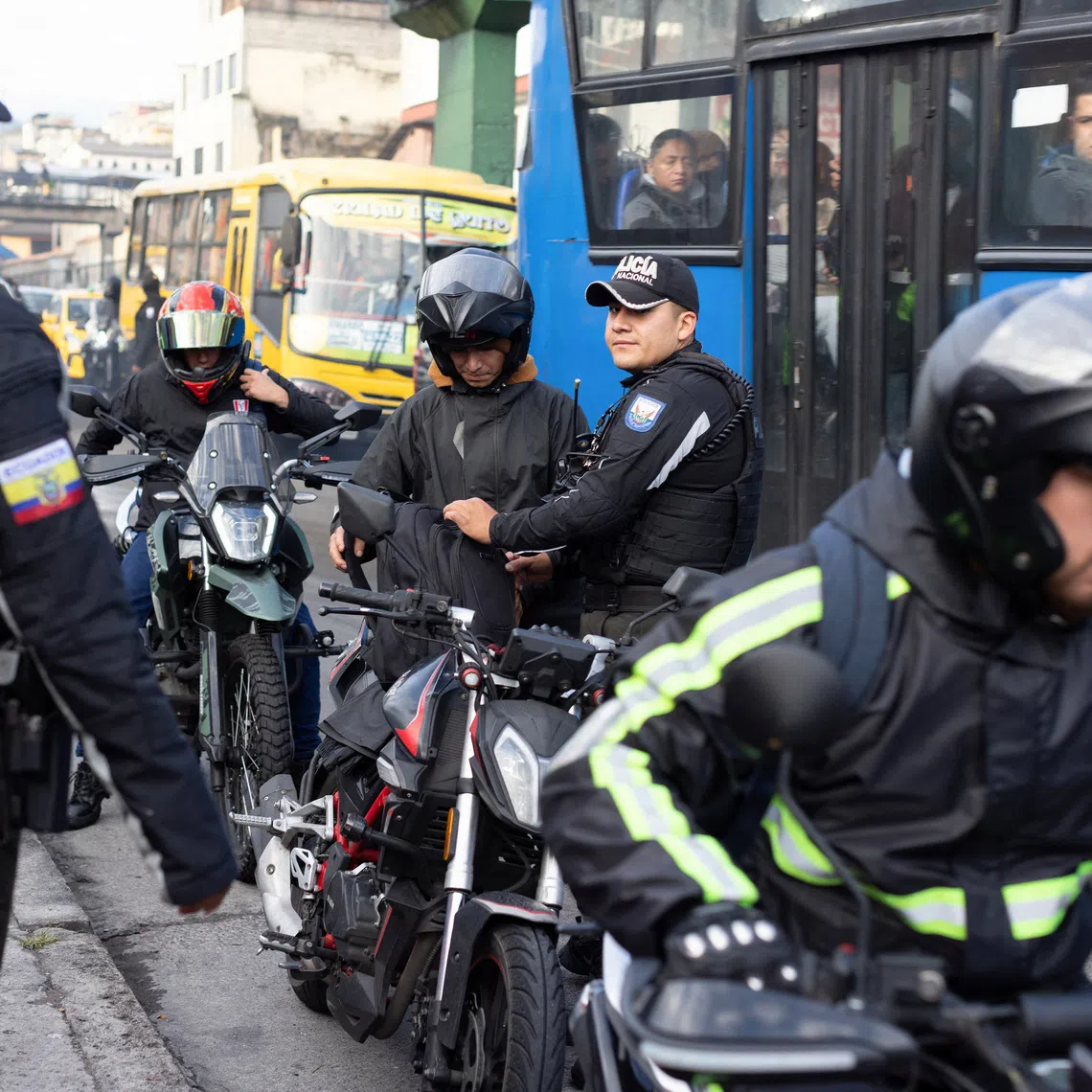 National Police officers search motorcyclists along a road in the San Roque neighborhood, as gangs gain a foothold in Ecuador's capital, in Quito, Ecuador, October 22, 2026. REUTERS/David Diaz Arcos