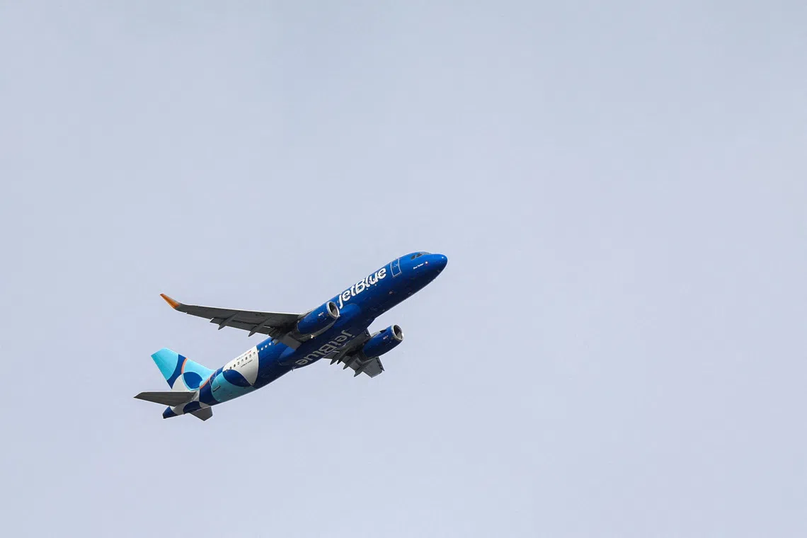 FILE: A JetBlue Airlines plane flies over the Queens borough of New York City, U.S., November 5, 2025. FILE/REUTERS/Kylie Cooper
