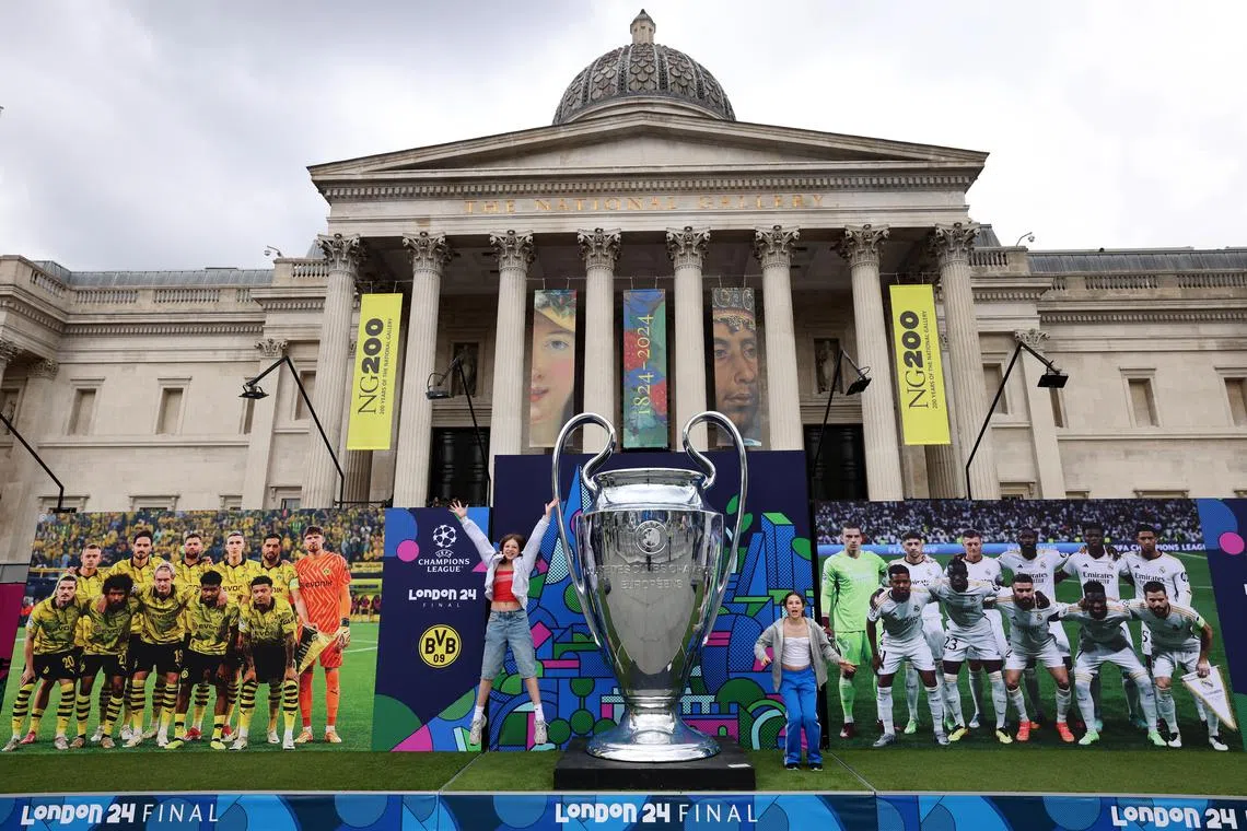 Fans posing with a replica of the Champions League trophy at the Champions Festival at Trafalgar Square in London on May 30.