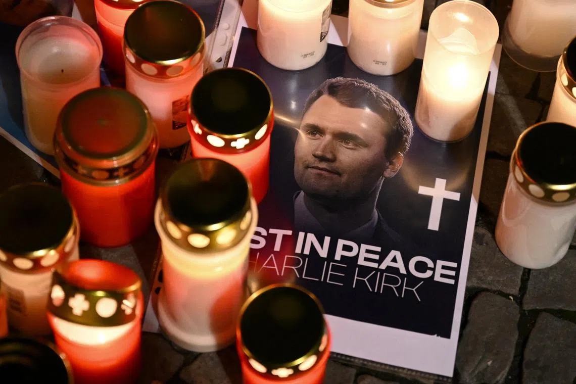 Candles are placed next to a picture of Charlie Kirk during a vigil under the line \"In Memory of Charlie Kirk, for freedom, patriotism and justice\" in front of the Embassy of the United States after U.S. right-wing activist, commentator, Charlie Kirk, an ally of U.S. President Donald Trump, was shot dead during an event at Utah Valley University, Orem, U.S., in Berlin, Germany September 11, 2025. REUTERS/Annegret Hilse