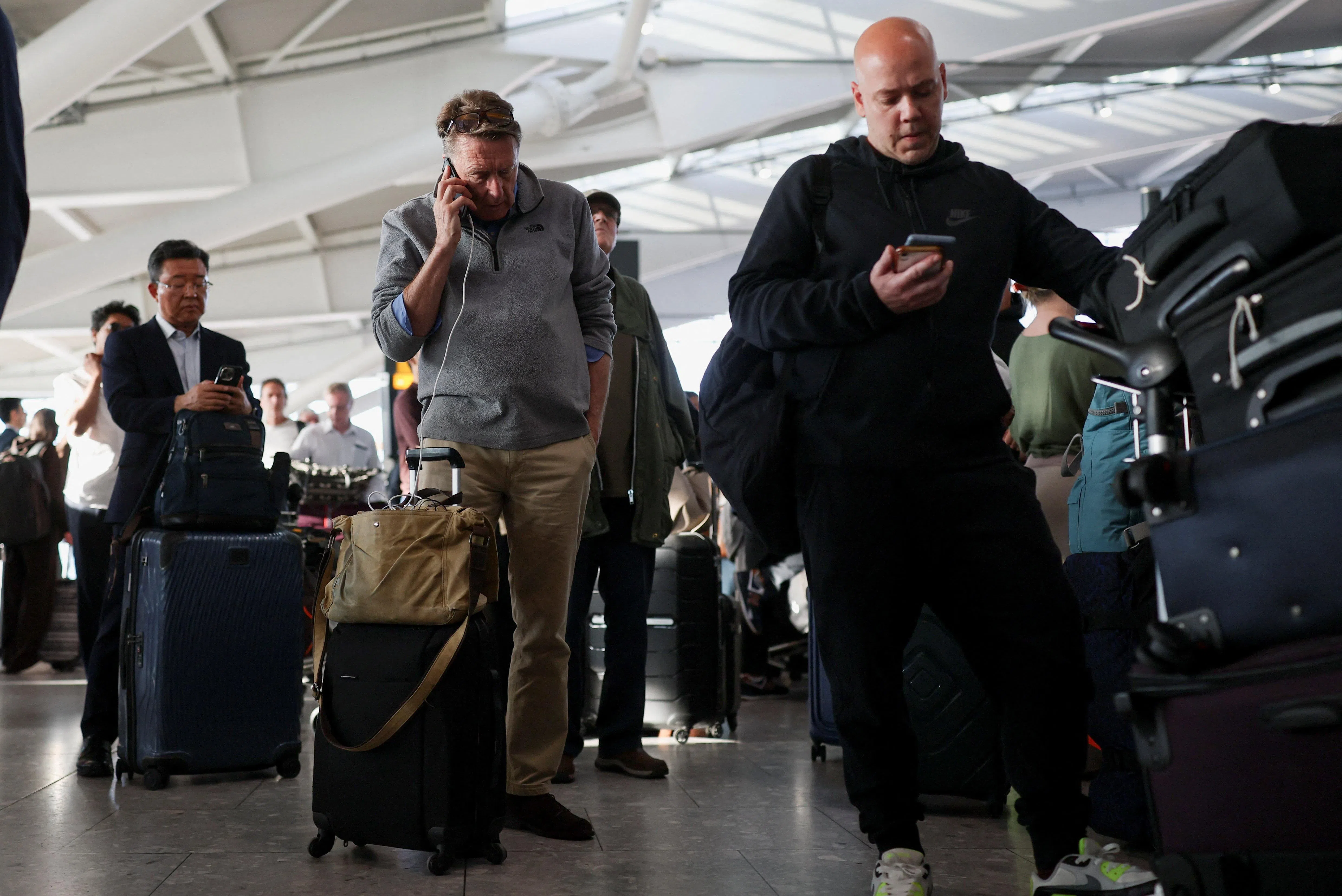 Stranded passengers using their phones at Heathrow Airport’s Terminal 5 in London, Britain, on Sept 8.