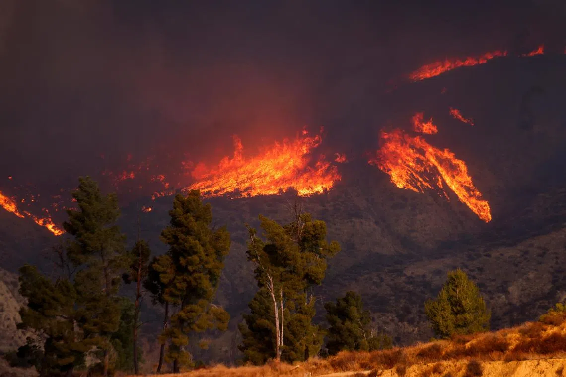 Smoke and flames rise as firefighters and aircraft battle the Hughes Fire near Castaic Lake, north of Santa Clarita, California, U.S. January 22, 2025. REUTERS/David Swanson
 