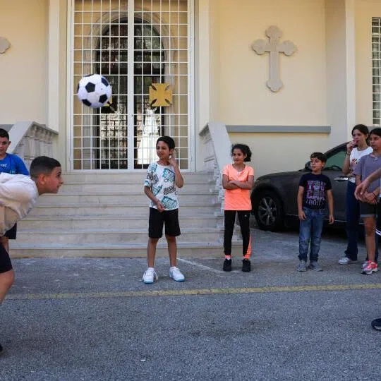 Christian children displaced from Tyre, in southern Lebanon, play football in the courtyard of the Greek Melkite Catholic Patriarchate in Rabweh, Lebanon.