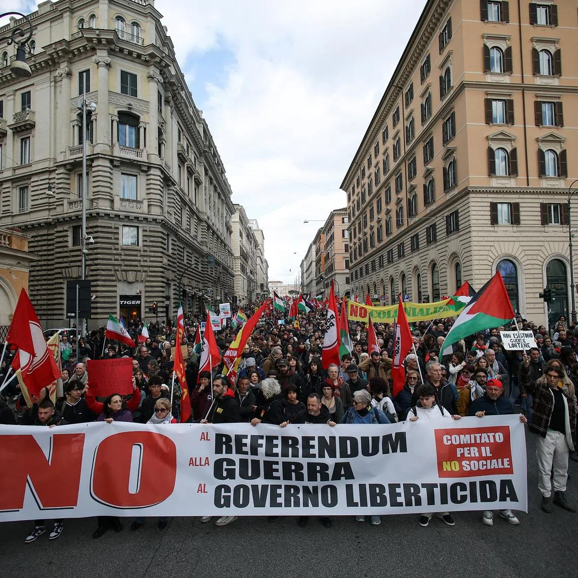 Demonstrators march with flags and banners during a protest supporting the \"No\" campaign ahead of Italy’s March 22–23 referendum on judicial reform and criticising the government of Prime Minister Giorgia Meloni’s foreign policies, in Rome, Italy, March 14, 2026. REUTERS/Francesco Fotia