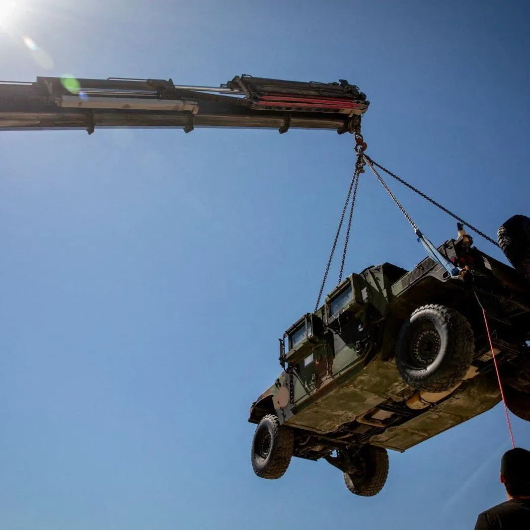 A crane hoists a tactical vehicle at the Logistics Support Area, in a location given as near Kerem Shalom, in this handout picture released June 30, 2026, by the Trump-appointed Board of Peace. Board of Peace/Handout via REUTERS  THIS IMAGE HAS BEEN SUPPLIED BY A THIRD PARTY. MANDATORY CREDIT. NO RESALES. NO ARCHIVES. VERIFICATION: Reuters could not independently verify the location and date of the pictures. However, the Board of Peace said that the Logistics Support Area is located near the Kerem Shalom crossing. No older versions of the photos were found posted online before June 30.