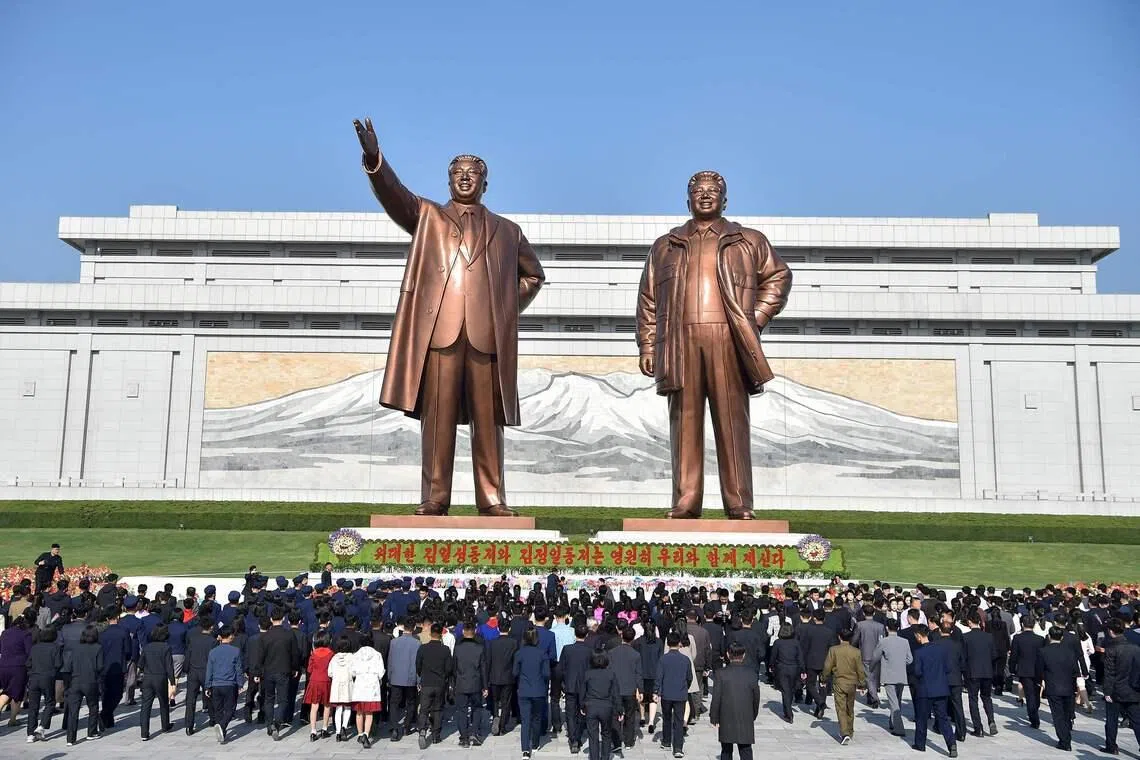 TOPSHOT - People pay tribute to the statues of late North Korean leaders Kim Il Sung and Kim Jong Il at Mansu Hill in Pyongyang on April 15, 2026, to mark the 114th birth anniversary of late leader Kim Il Sung, celebrated as the "Day of the Sun". (Photo by KIM Won Jin / AFP)