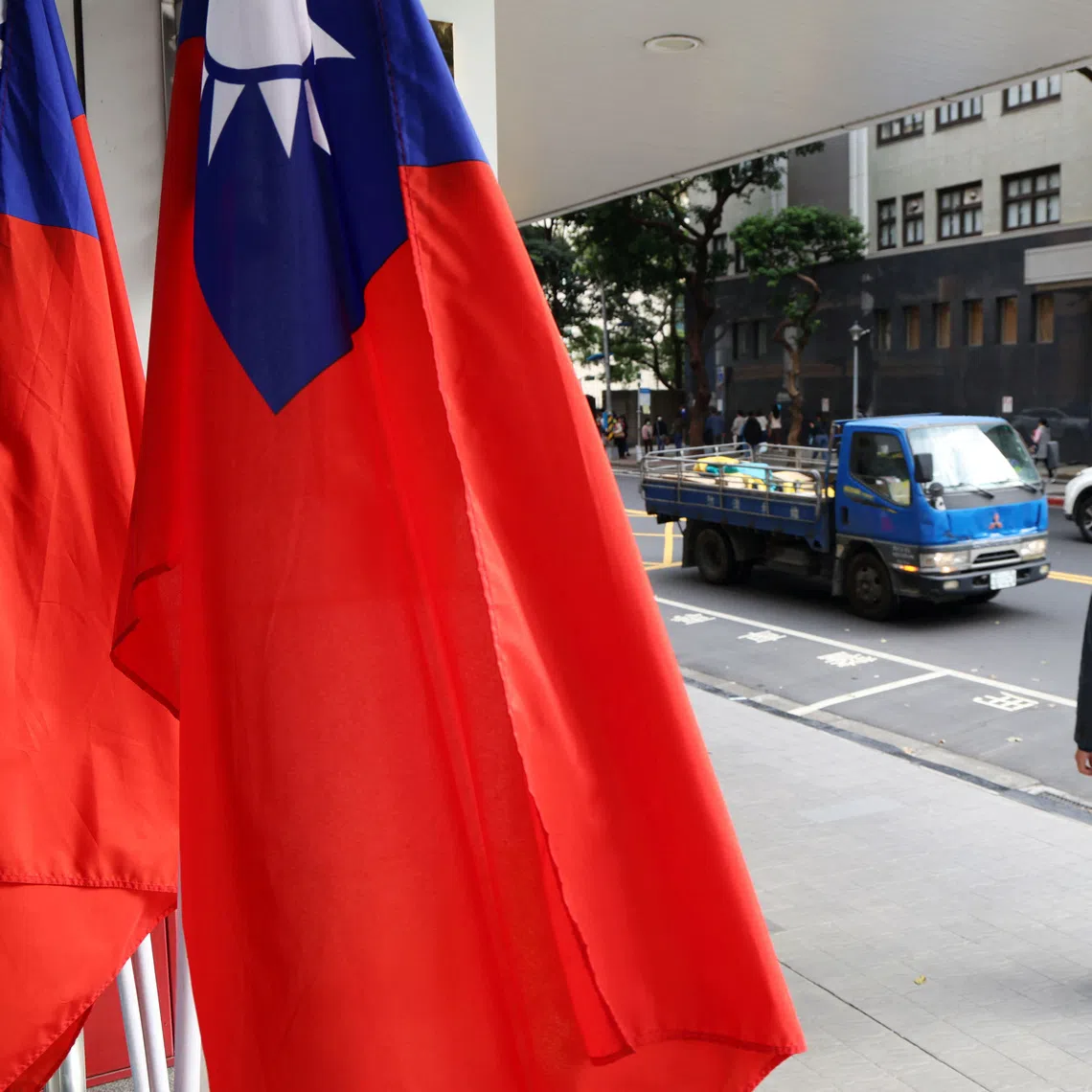 A man walks past Taiwan flags on a street amid China's \"Justice Mission 2025\" military drills around Taiwan, in Taipei, Taiwan December 29, 2025. REUTERS/Tsai Hsin-Han