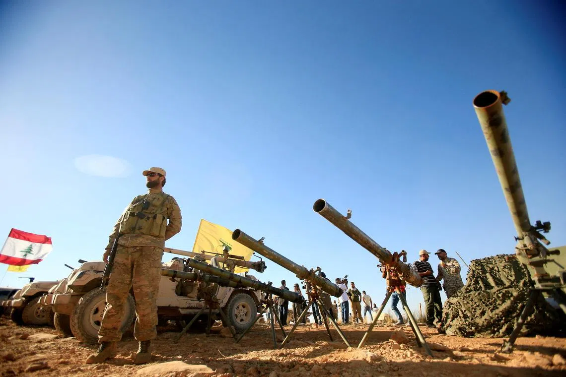 FILE PHOTO: A Hezbollah fighter stands in front of anti-tank artillery at Juroud Arsal, the Syria-Lebanon border, July 29, 2017. REUTERS/Ali Hashisho/File Photo