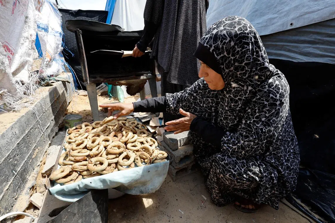 A displaced Palestinian family makes traditional cakes as they prepare for the Eid al-Fitr holiday which marks the end of the Muslim holy fasting month of Ramadan, amid the ongoing conflict between Israel and Hamas, at a tent camp in Rafah, in the southern Gaza Strip, April 8, 2024. REUTERS/Mohammed Salem
