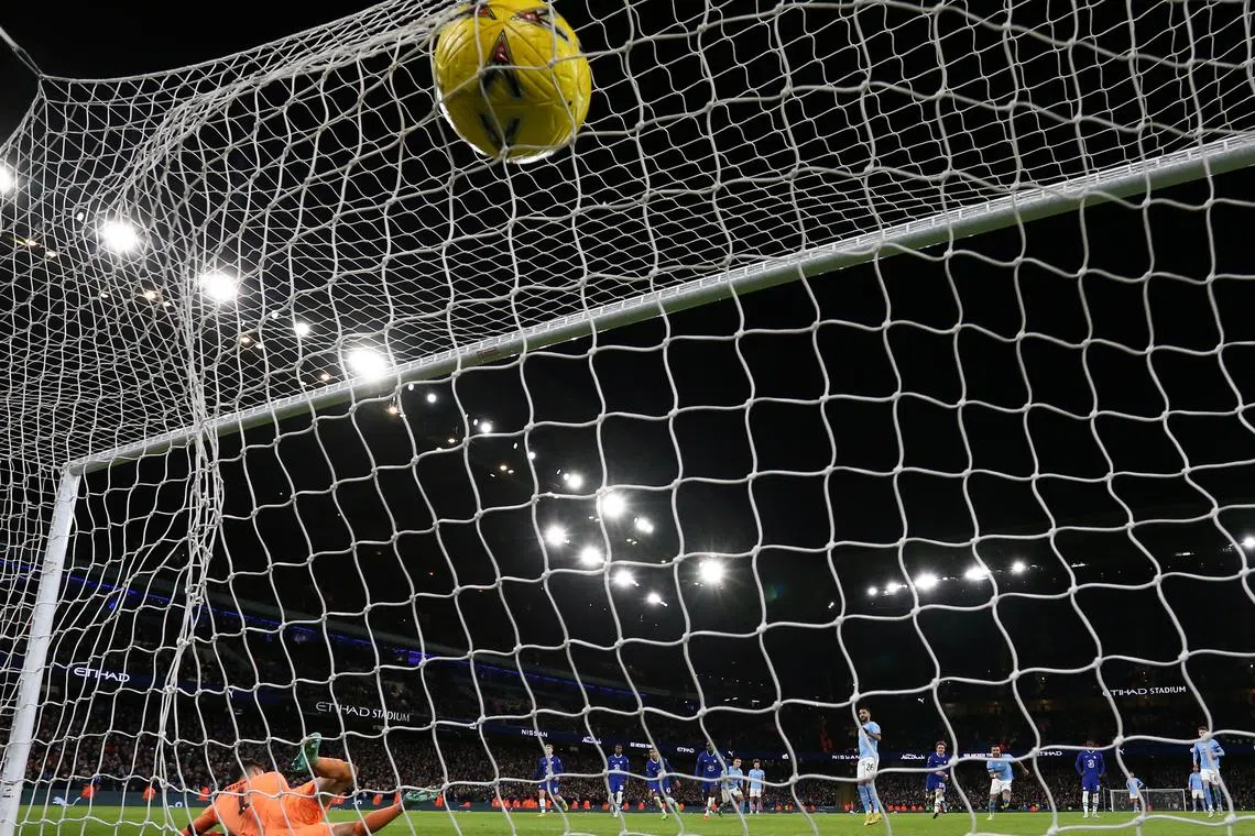 Manchester City's Riyad Mahrez scores the 4-0 past Chelsea's goalkeeper Kepa Arrizabalaga.
