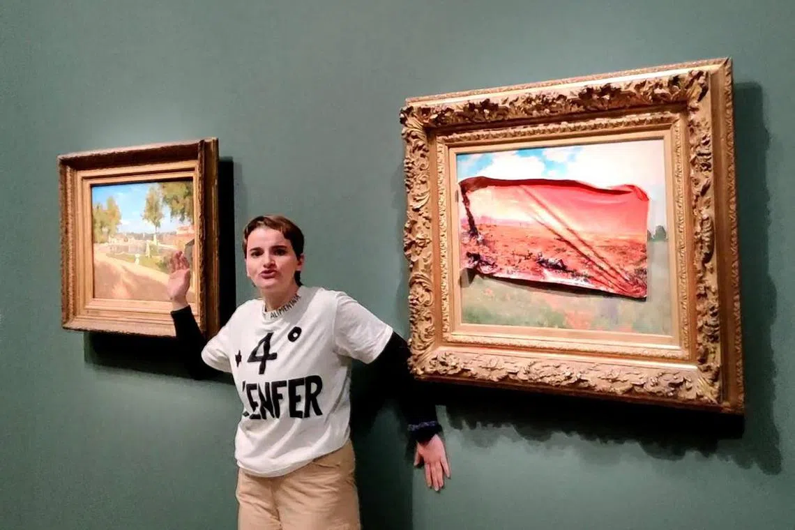 A photo by the Riposte Alimentaire collective shows a member of the group wearing a T-shirt reading "+4° the hell", after covering Claude Monet's painting Les Coquelicots, with an adhesive poster.