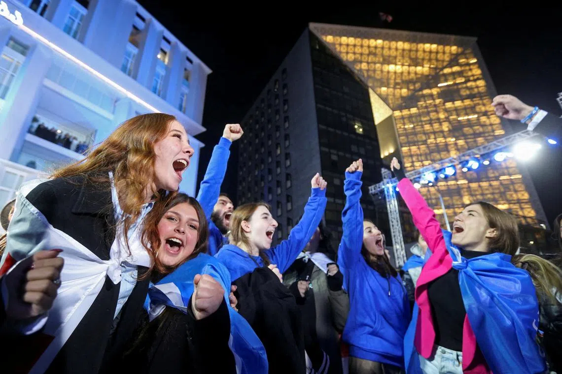 Supporters of the Georgian Dream party celebrate at the party's headquarters after the announcement of exit poll results in parliamentary elections, in Tbilisi, Georgia October 26, 2024. REUTERS/Irakli Gedenidze