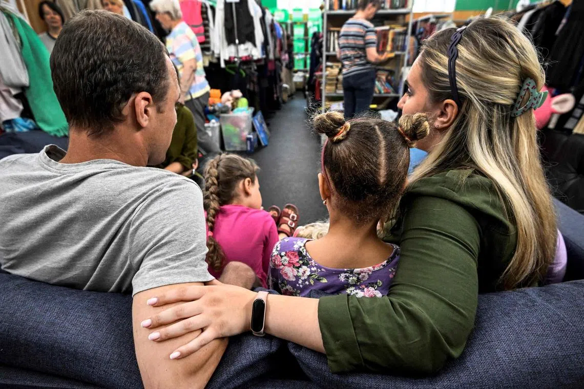 Yulia (R) and Alexander (L) with their children, who fled the town of Kupyansk in northeastern Ukraine, sit at the humanitarian aid warehouse of the Mayak Foundation in Moscow on August 9, 2023. For a year and a half Galina Artyomenko had been raising funds to help refugees from Ukraine after the Kremlin sent troops to the pro-Western country. (Photo by Alexander NEMENOV / AFP)