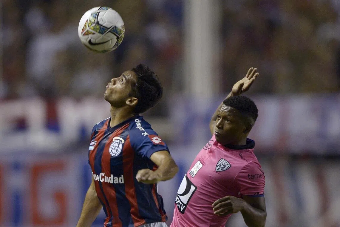 Midfielder Jonathan Gonzalez of Ecuador's Independiente del Valle, vies for the ball with defender Emmanuel Mas of Argentina's San Lorenzo during their Libertadores Cup Group 2 football match at Pedro Bidegain stadium in Buenos Aires.