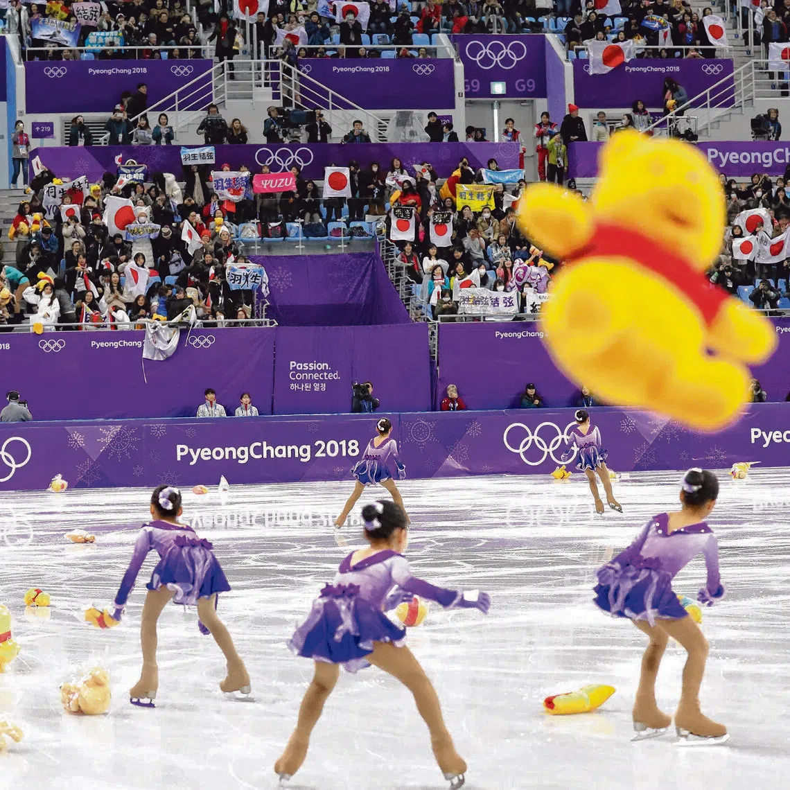 Flower girls race on the ice to collect tens of yellow Winnie-the-Pooh bears thrown on the ice after Yuzuru Hanyu of Japan competed during the PyeongChang 2018 Olympic Games.