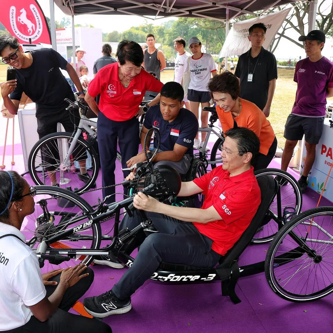 Prime Minister Lawrence Wong (seated) trying out a recumbent hand cycle at the launch of the inaugural Paralympic Day at Angsana Green, East Coast Park, on Aug 29, 2026.