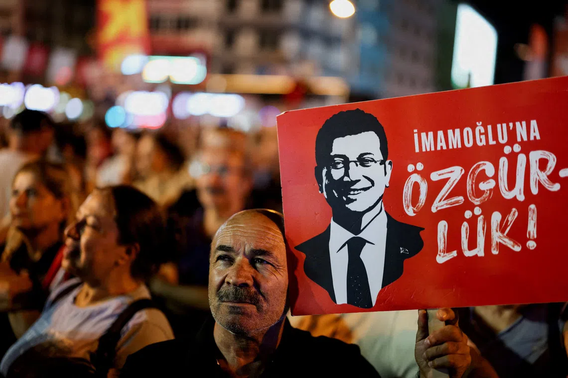 FILE PHOTO: A man holds up a sign featuring an image of Istanbul Mayor Ekrem Imamoglu during a rally to protest against a recent court ruling that ousted the main opposition Republican People's Party's (CHP) Istanbul provincial leadership, in Istanbul, Turkey, September 10, 2025. REUTERS/Umit Bektas/File Photo