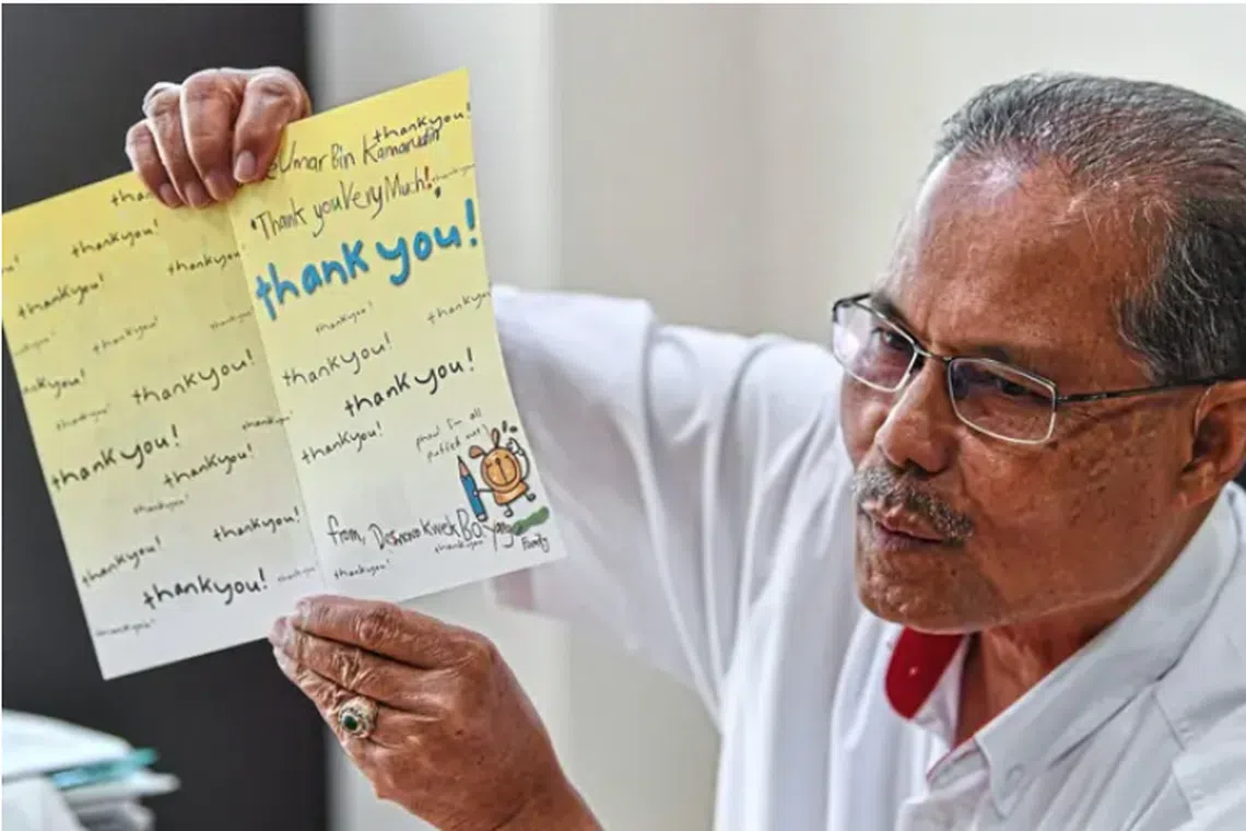 Mr Umar showing the thank you card he received from the Kweks nearly 20 years ago.