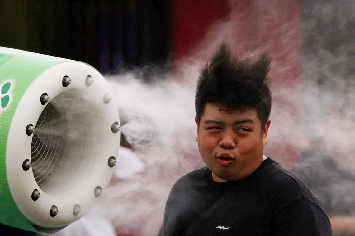 A tourist cooling off in front of a misting fan at Sensoji temple, in Tokyo, Japan, July 10, 2025. 
