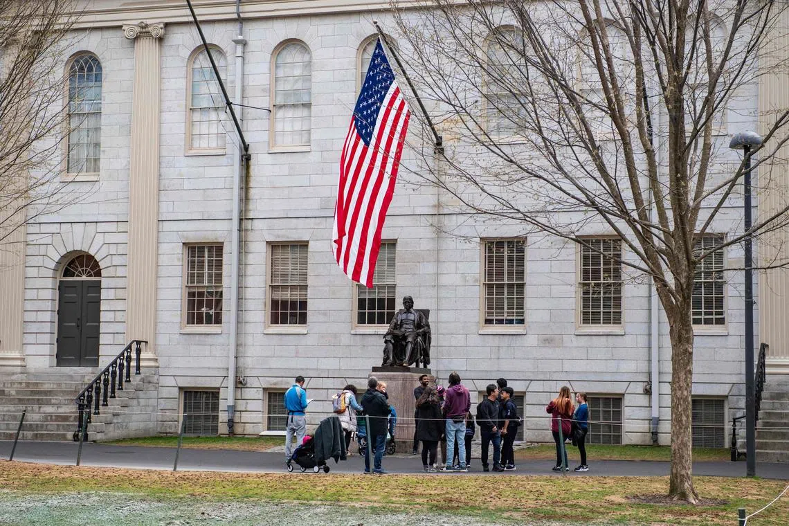 People gather around the John Harvard Statue on the Harvard University campus in Cambridge, Massachussetts, on April 15. 