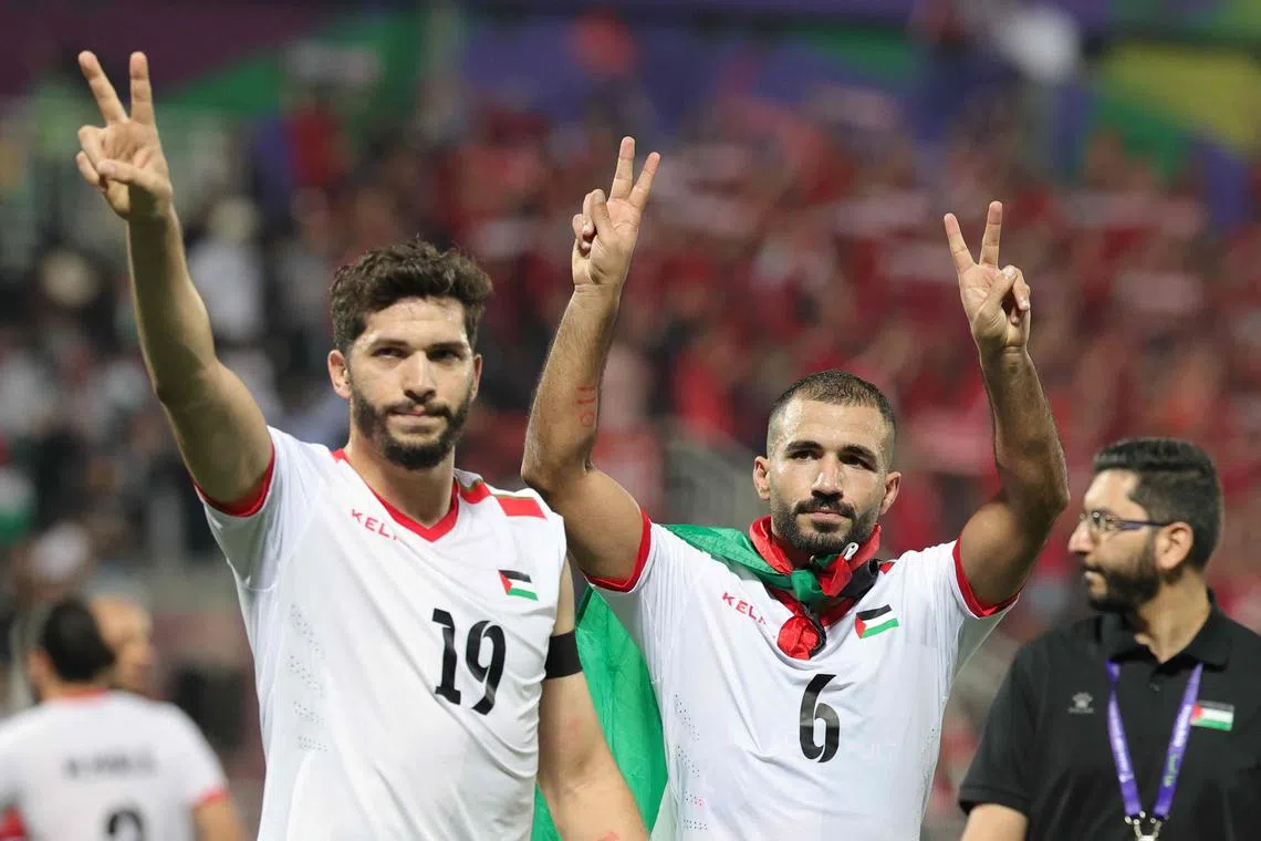 Palestine forward Mahmoud Wadi and midfielder Oday Kharoub applaud supporters, after beating Hong Kong 3-0 to qualify for the Asian Cup last 16.
