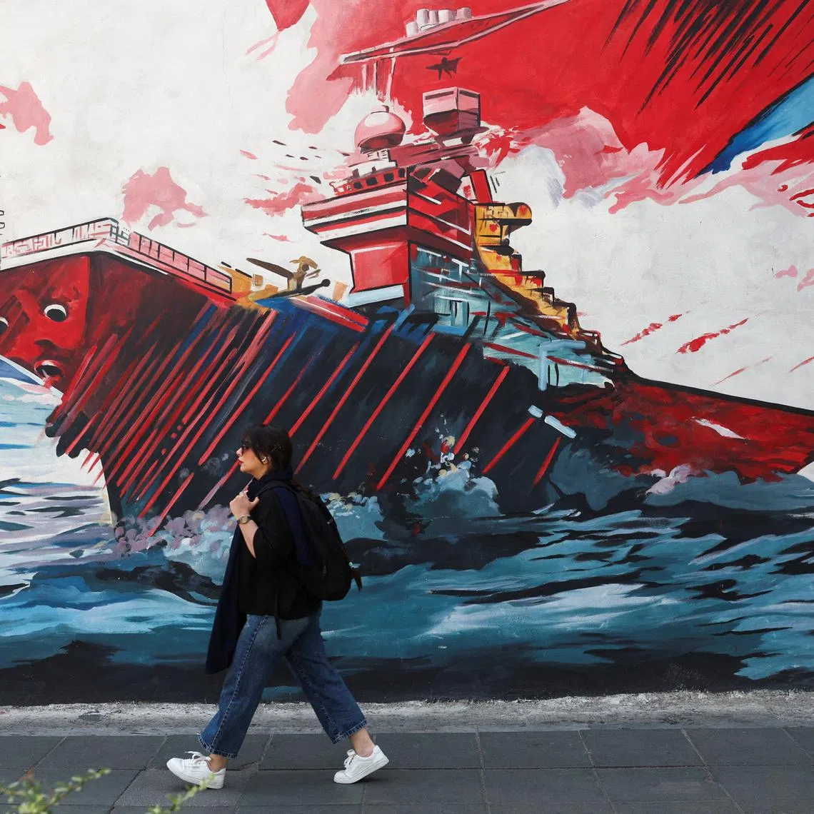 An Iranian woman walks next to an anti-U.S. mural on a street in Tehran, Iran, June 10, 2026. Majid Asgaripour/WANA (West Asia News Agency) via REUTERS