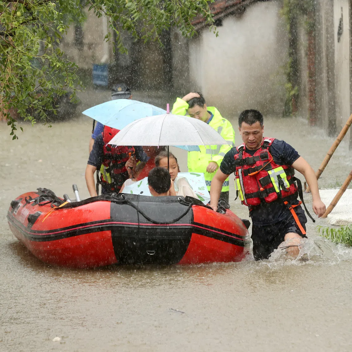 Rescue workers evacuate stranded villagers by lifeboat at a flooded village, following heavy rainfall brought by the remnants of Typhoon Dolphin, in Deqing county, Huzhou, on Aug 14.