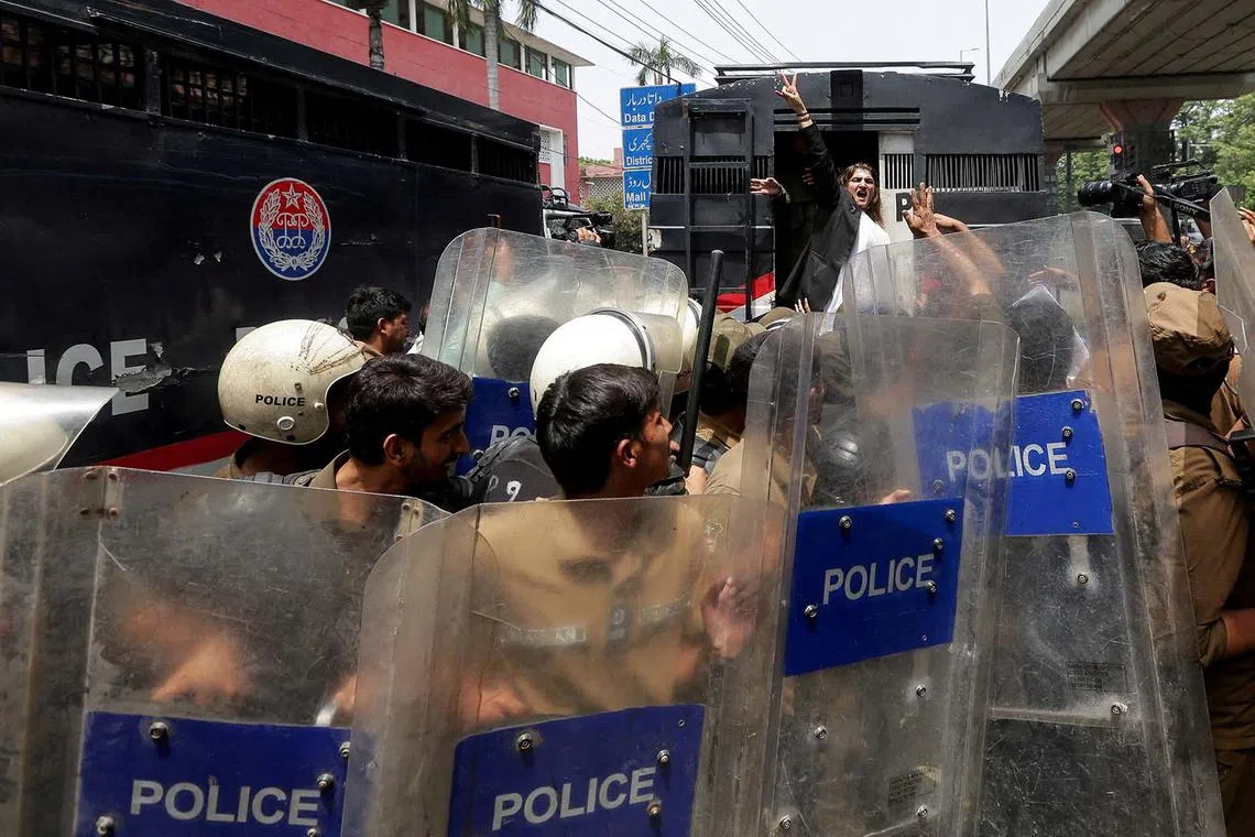 A supporter of Pakistan's former Prime Minister Imran Khan and his party, Pakistan Tehreek-e-Insaf (PTI), chanting slogans while being detained by police officers during a nationwide protest demanding Khan's release on the second anniversary of his jailing, in Lahore, Pakistan, Aug 5, 2025. 