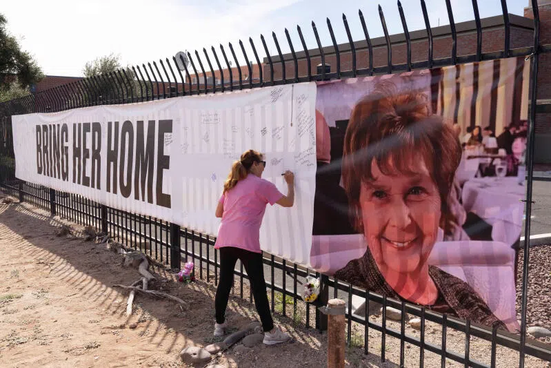Actress Jennifer Bond signs a banner that reads "Bring her home" and shows a photo of Nancy Guthrie who went missing on Feb 1.