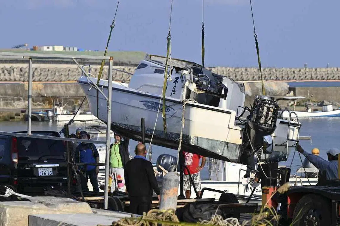 The Fukutsu, one of two boats that capsized in Nago, Okinawa, in March, being brought ashore on March 16. Two people, including a 17-year-old student, died in the incident.